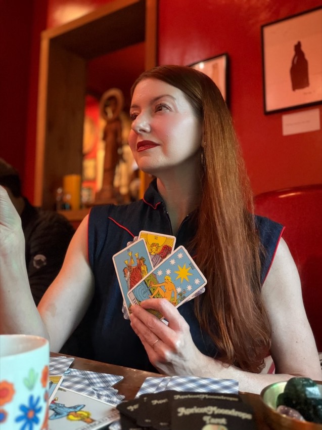 Suzanne holding a fan of tarot cards during a reading